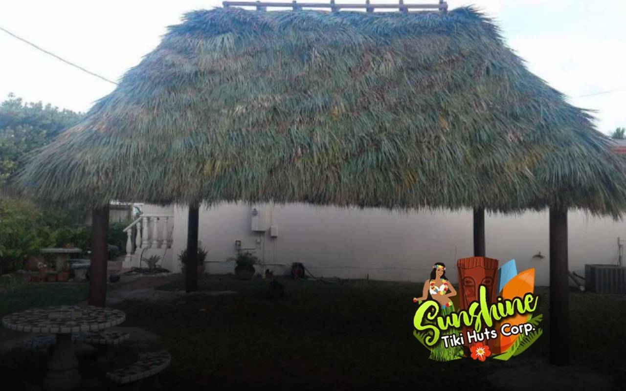 Backyard tiki hut providing shaded seating in a garden
